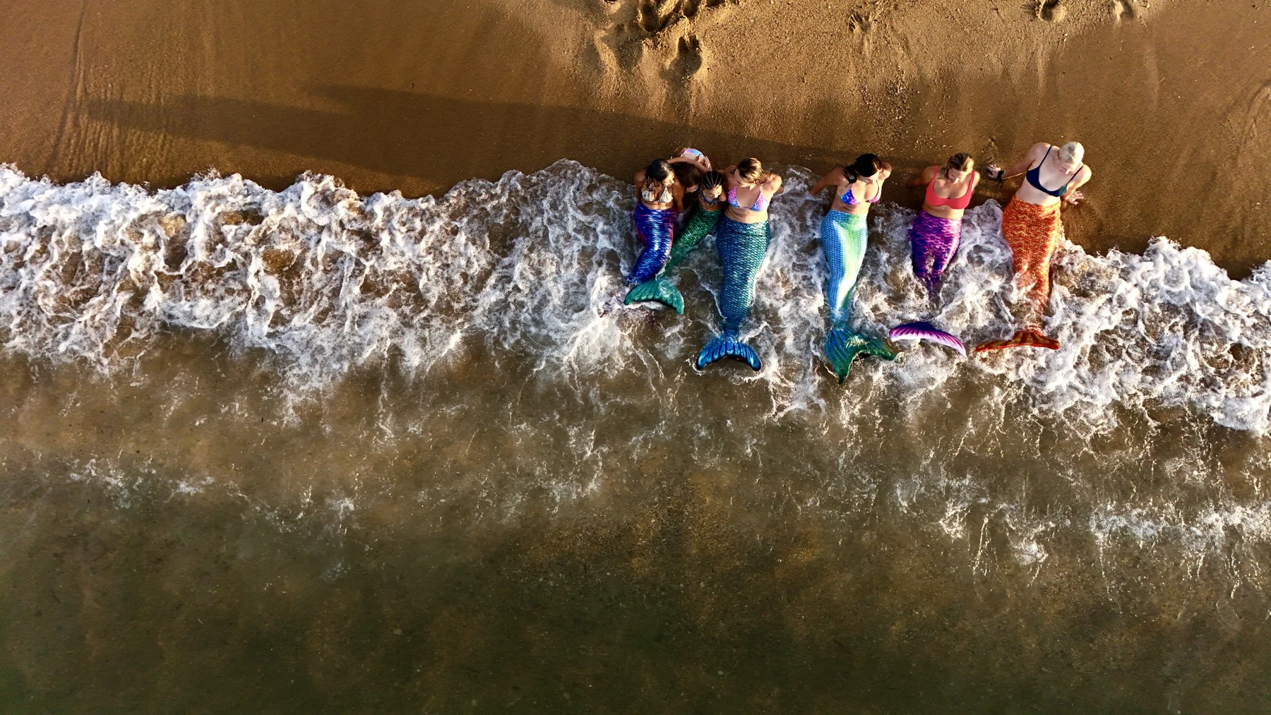 Mermaids photographed from above in clear water